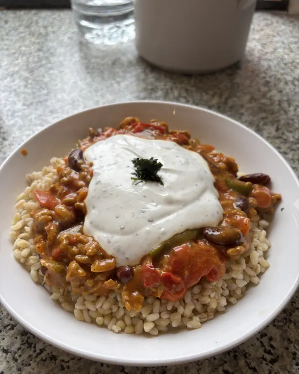 Assiette de céréales, chili aux haricots rouges et sauce blanche