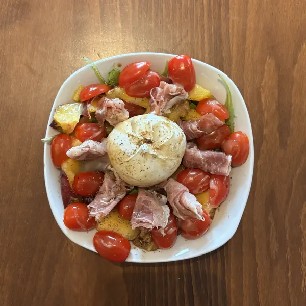 Assiette de burrata, tomates cerises, jambon cru et quartiers de pêche