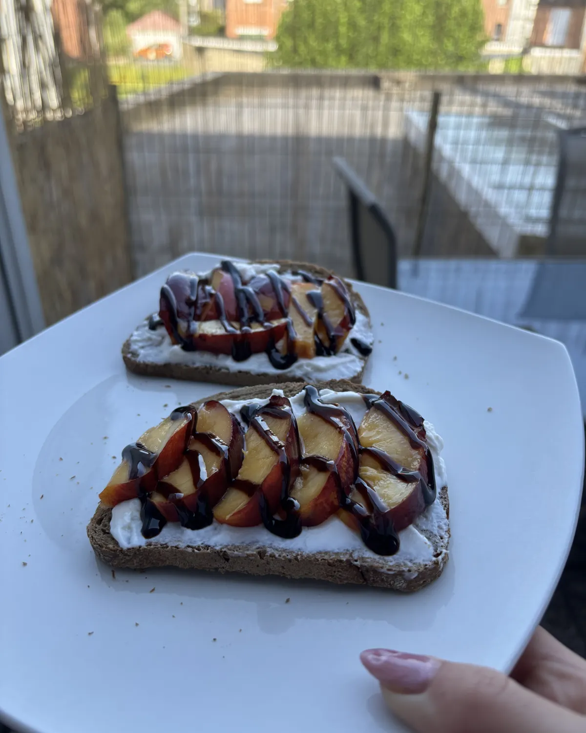 Tartines garnies de fromage frais et de quartiers de prunes, nappées de crème balsamique